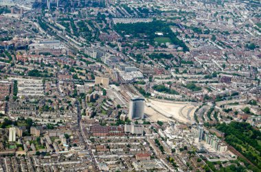Güneşli bir sabahta Londra 'nın merkezindeki Earls Court ve Holland Park bölgelerinde kuzeye bakan hava manzarası. İmparatoriçe Devlet Binası ortaya doğru..  