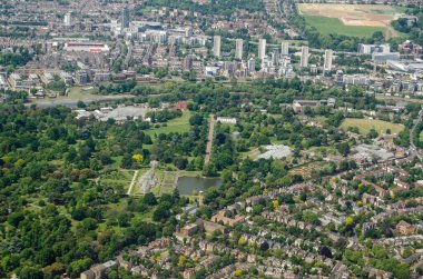 Güneşli bir yaz gününde Batı Londra 'daki Kew' deki tarihi Kraliyet Botanik Bahçeleri 'nin hava manzarası. Palm House, Brentford Futbol Kulübü 'nün sol üstteki stadyumuyla görüntünün ortasında yer alıyor..  