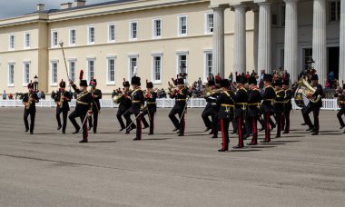 Sandhurst, Berkshire, İngiltere - 16 Haziran 2019: The Drum Major etkileyici topuzunu bir yaz günü Sandhurst Askeri Akademisi 'nin önündeki bir gösteride Kraliyet Topçu Grubu' nun müzisyenlerini yönetmek için kullandı..