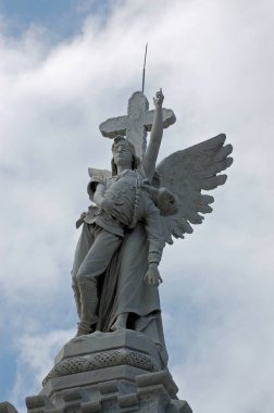 Düşmüş bir itfaiyeciyi cennete götüren bir melek heykeli. İtfaiyeci anıtının ayrıntıları Havana 'daki Kristof Kolomb mezarlığında La Necropolis de Cristobal Colon olarak bilinen 1890' da öldürülen 28 itfaiyeci için bir anıttır..