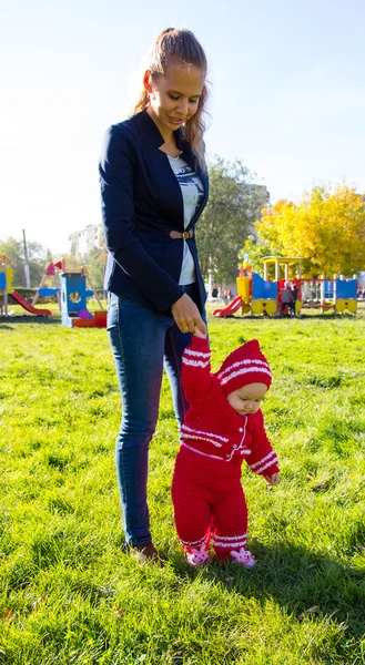Pequeño bebé aprendiendo a caminar. Mamá sosteniendo la mano del bebé —  Fotos de Stock