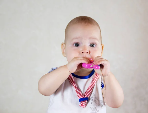 En liten baby som leker med leker. Små barn tygger på leketøy – stockfoto