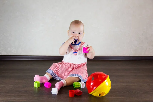 Pequeño bebé jugando con juguetes. Niño pequeño mastica un juguete —  Fotos de Stock