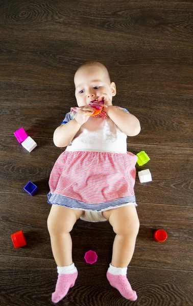 Pequeño bebé jugando con juguetes. Niño pequeño mastica un juguete —  Fotos de Stock