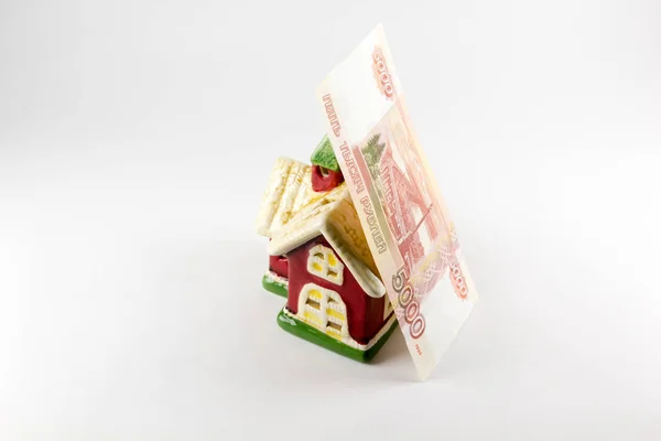 Casa y cinco mil rublos de dinero sobre un fondo blanco — Foto de Stock