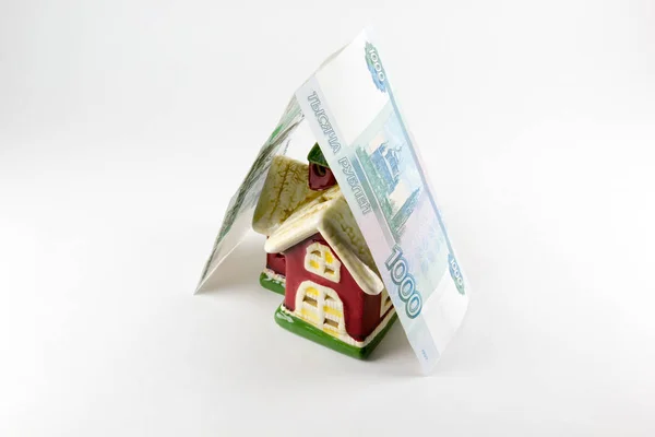 Casa y mil rublos de dinero sobre un fondo blanco — Foto de Stock