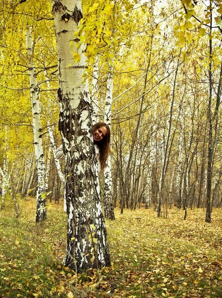 Neşeli kadın bir ağacın arkasından bakıyor — Stok fotoğraf