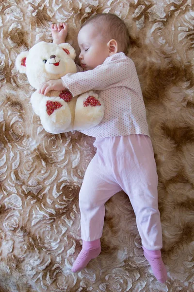 Yeni doğan bebek bir oyuncak ayı ile uyur