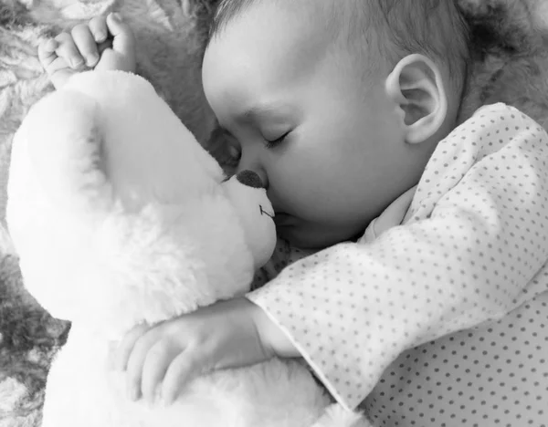 Bebé recién nacido duerme con un oso de peluche blanco y negro — Foto de Stock