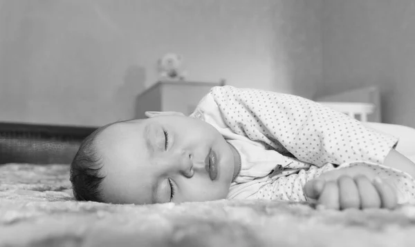 Mignon nouveau-né dormir sur le lit noir et blanc — Photo