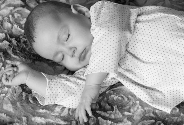 Bonito bebê recém-nascido dormindo na cama preto e branco — Fotografia de Stock