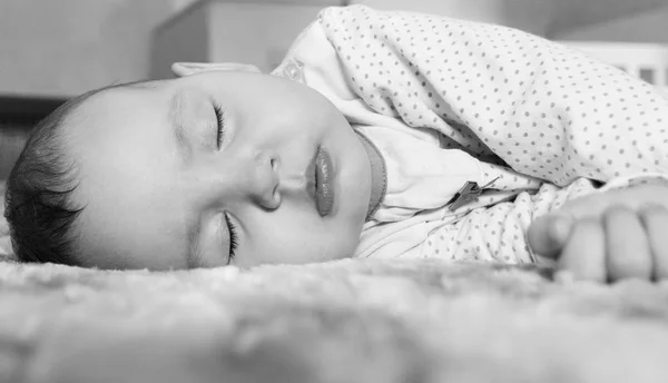 Szép újszülött baba alszik az ágyban fekete-fehér — Stock Fotó