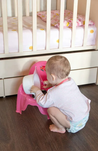 Toddler playing with baby potty — Stock Photo, Image