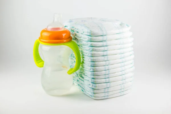 Bebek bezi ve şişe üzerinde beyaz bir arka plan — Stok fotoğraf