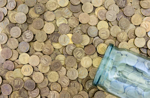 Много монет и стеклянная банка — стоковое фото