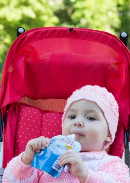 The baby eats a puree from a supermarket — Stock Photo, Image