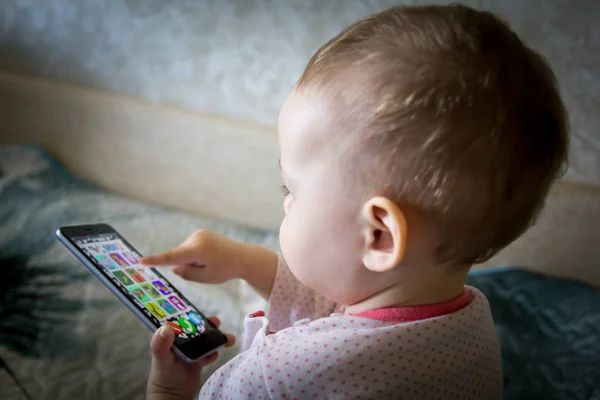 El bebé está jugando con un teléfono inteligente —  Fotos de Stock