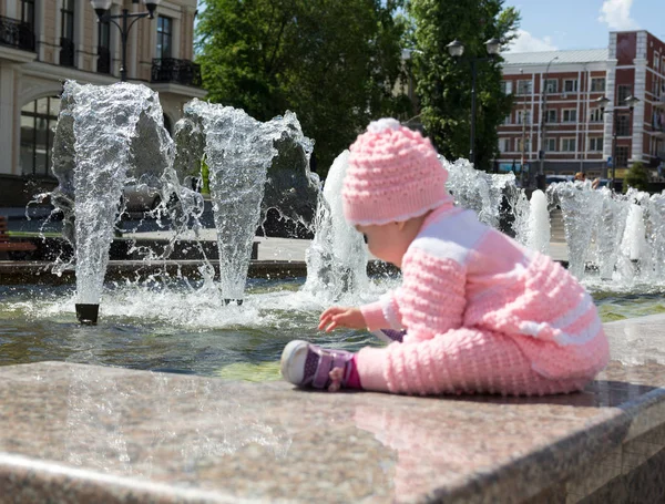O bebé está a brincar na fonte. — Fotografia de Stock