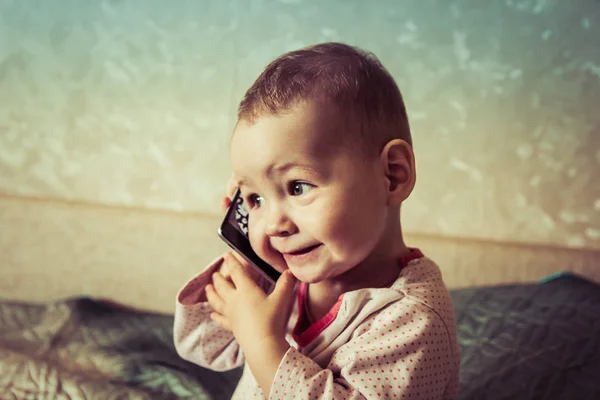 El bebé está jugando con un teléfono inteligente — Foto de Stock