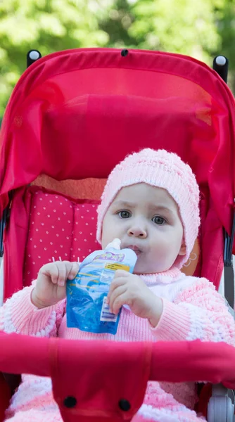 The baby eats a puree from a supermarket — Stock Photo, Image