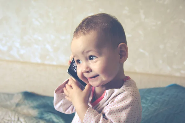 El bebé está jugando con un teléfono inteligente —  Fotos de Stock