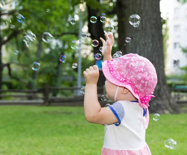 Retrato de um bebê e bolhas de sabão — Fotografia de Stock