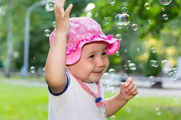 Retrato de um bebê e bolhas de sabão — Fotografia de Stock