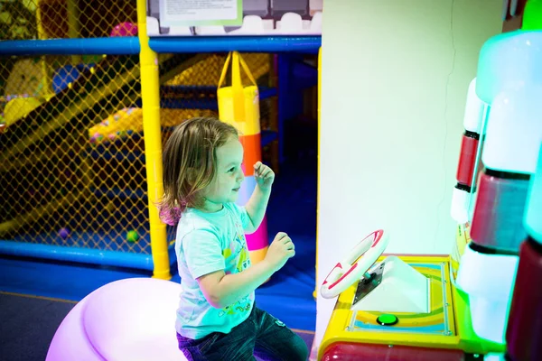 Un niño juega en una máquina tragaperras para niños en un entretenimiento — Foto de Stock