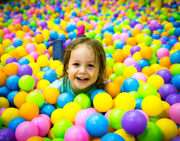 El niño juega en la piscina con pelotas. Una cabeza sobresale — Foto de Stock