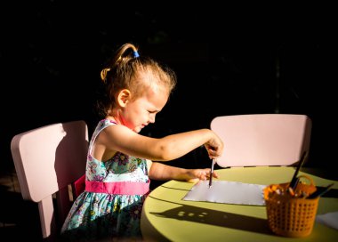 Yetenekli çocuk resim çizer ve çizer.