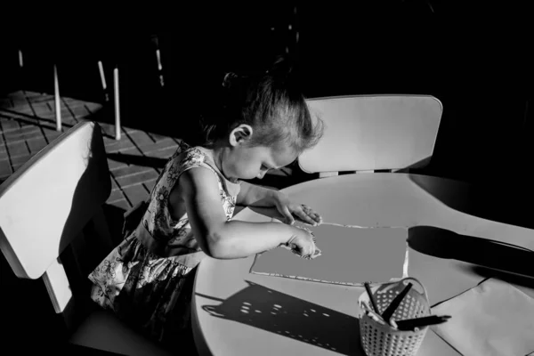 Niño talentoso dibuja y pinta cuadros en blanco y negro — Foto de Stock