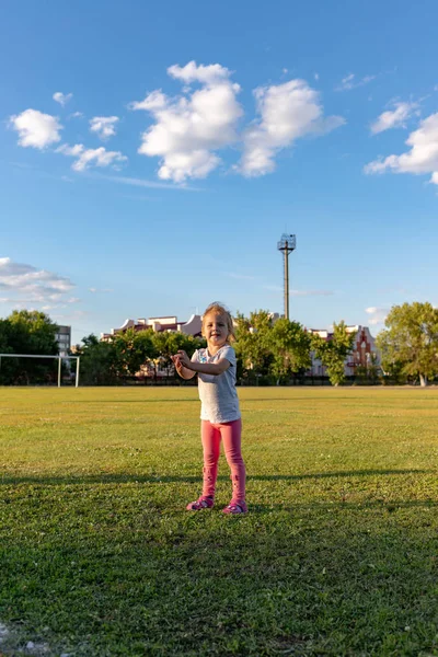 Un niño pequeño va a practicar deportes en el estadio. colgando en la barra horizontal, en las barras irregulares —  Fotos de Stock