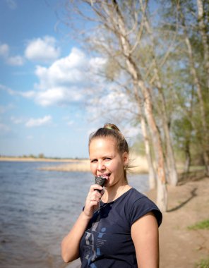 Siyah bir waffle bardağında dondurma yiyen genç bir kadın.