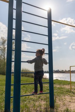 Küçük bir çocuk İsveç duvarına tırmanıyor.