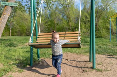 Çocuk salıncak sallıyor. Çocuk salıncakta oturuyor