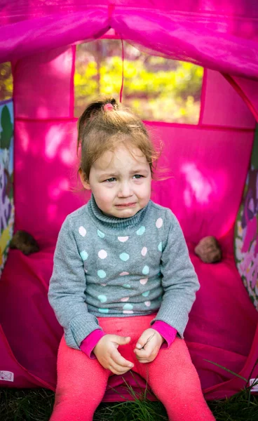 Triste, niño molesto sentado en una tienda en el jardín —  Fotos de Stock