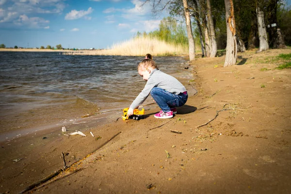 Kind spielt mit Spielzeugauto-LKW am Strand — Stockfoto