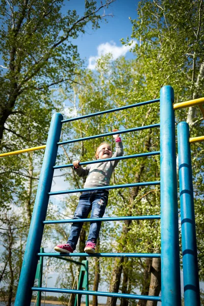 Un niño pequeño sube la pared sueca al aire libre —  Fotos de Stock