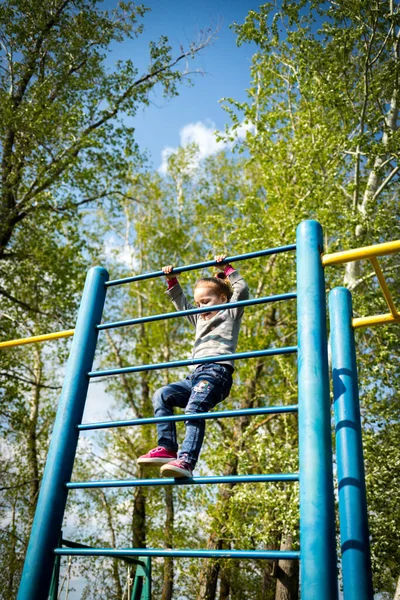 Ein kleines Kind erklettert die schwedische Mauer im Freien — Stockfoto