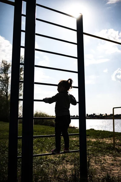 Un niño pequeño sube la pared sueca al aire libre —  Fotos de Stock