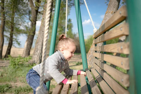 Niño balanceando un columpio. niño sentado en un columpio —  Fotos de Stock