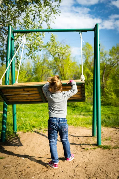 Niño balanceando un columpio. niño sentado en un columpio —  Fotos de Stock