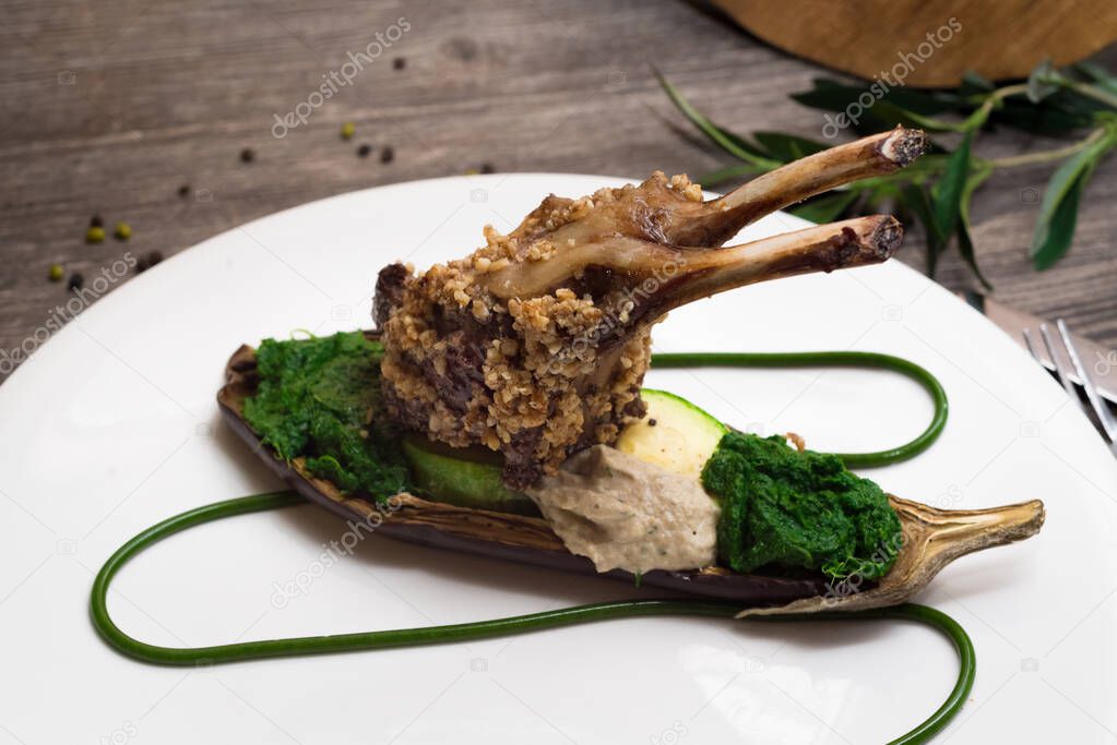 Rack of lamb in nut batter with baked vegetables spinach and eggplant