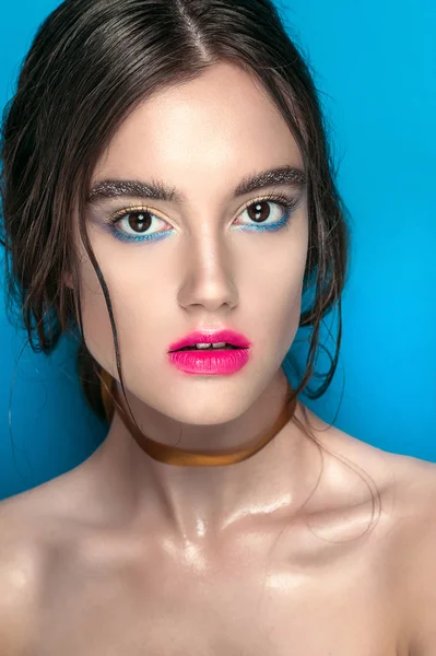 Retrato de chica de belleza con maquillaje vívido. Retrato de mujer de moda de cerca sobre fondo azul. Colores brillantes. Maquillaje de manicura. Ojos humeantes, pestañas largas. Rainbow Colors. Disparo retoque — Foto de Stock