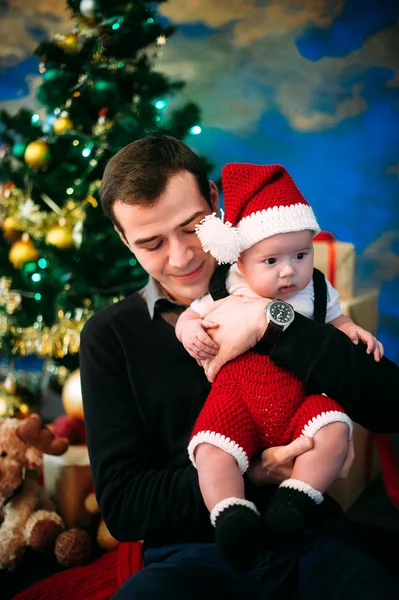 Söt liten pojke och hans pappa sitter vid julgran — Stockfoto