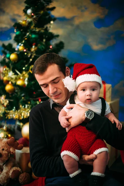 Anak kecil yang lucu dan ayahnya duduk di pohon Natal — Stok Foto