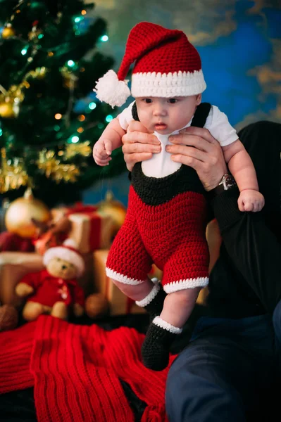 Saga porträtt av jul söta lilla bebis klädd som jultomte på nyår bakgrunden under träd — Stockfoto