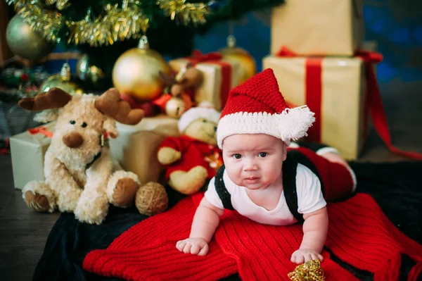 Retrato de cuento de hadas de Navidad lindo bebé vistiendo como Santa Claus en el fondo del año nuevo bajo el árbol — Foto de Stock