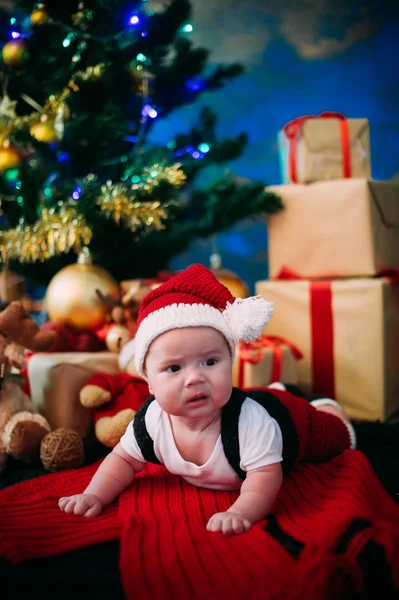 Казковий портрет різдвяної милої маленької дитини, що носить як Санта-Клаус на новорічному фоні під деревом — стокове фото