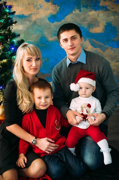 Retrato de família amigável olhando para a câmera na noite de Natal — Fotografia de Stock